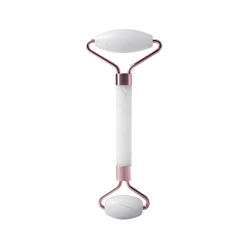 White and rose gold facial roller on a white background