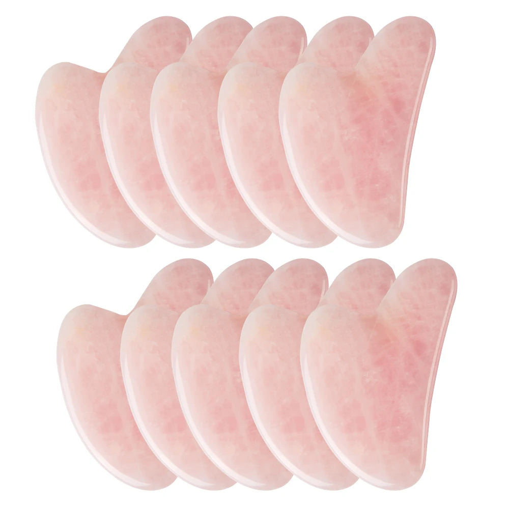 Set of 10 rose quartz gua sha on a white background