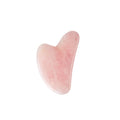Rose quartz gua sha tool on a white background