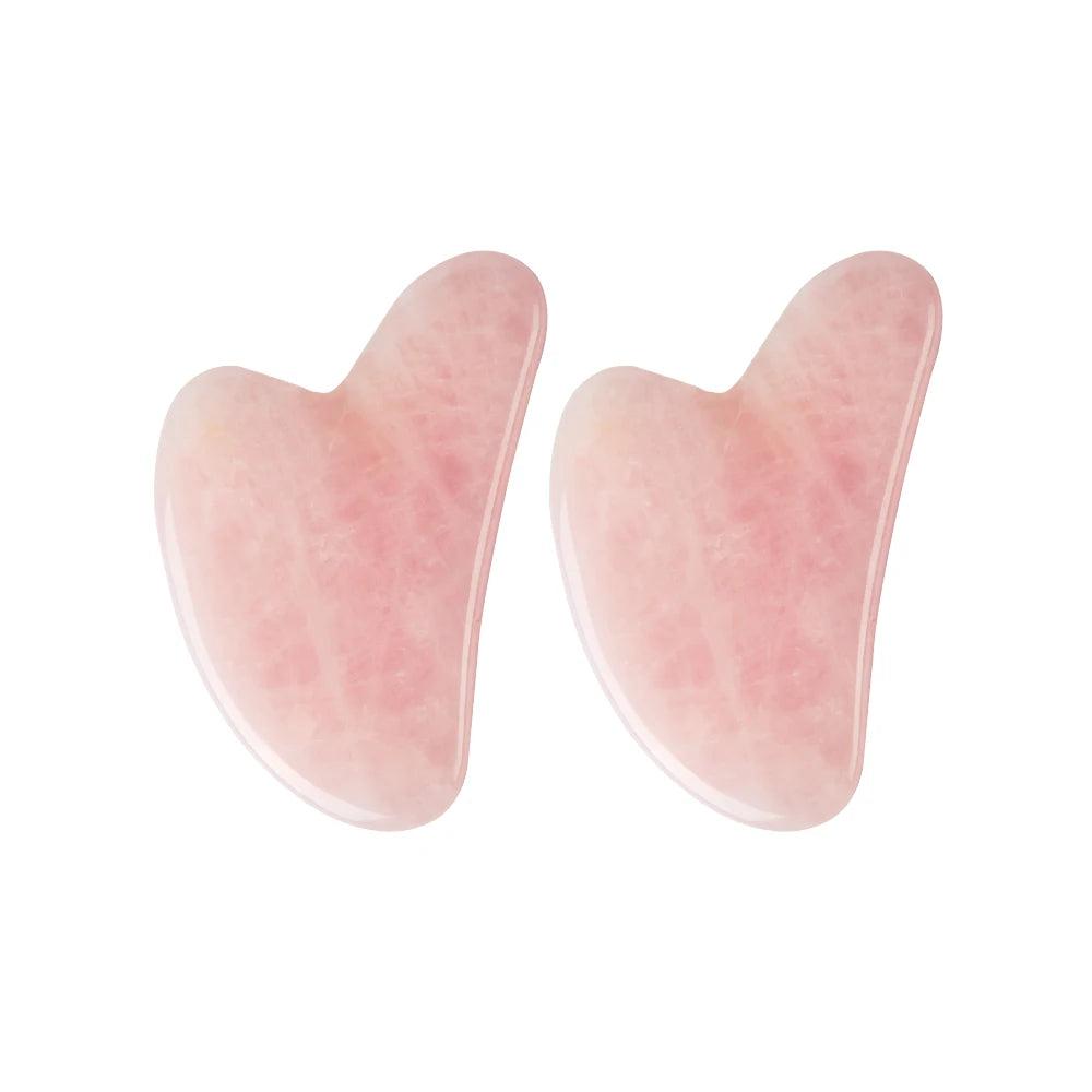 Two rose quartz gua sha tools on a white background